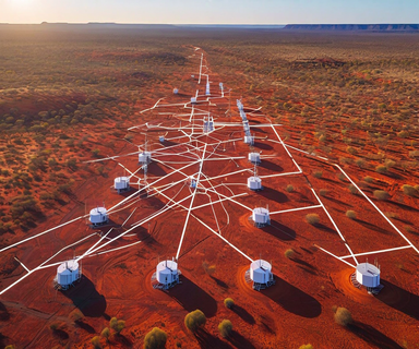 Aerial view of the Warramunga seismic array stations distributed across the Australian outback desert, showing white monitoring equipment arranged in a geometric pattern on red earth under clear skies